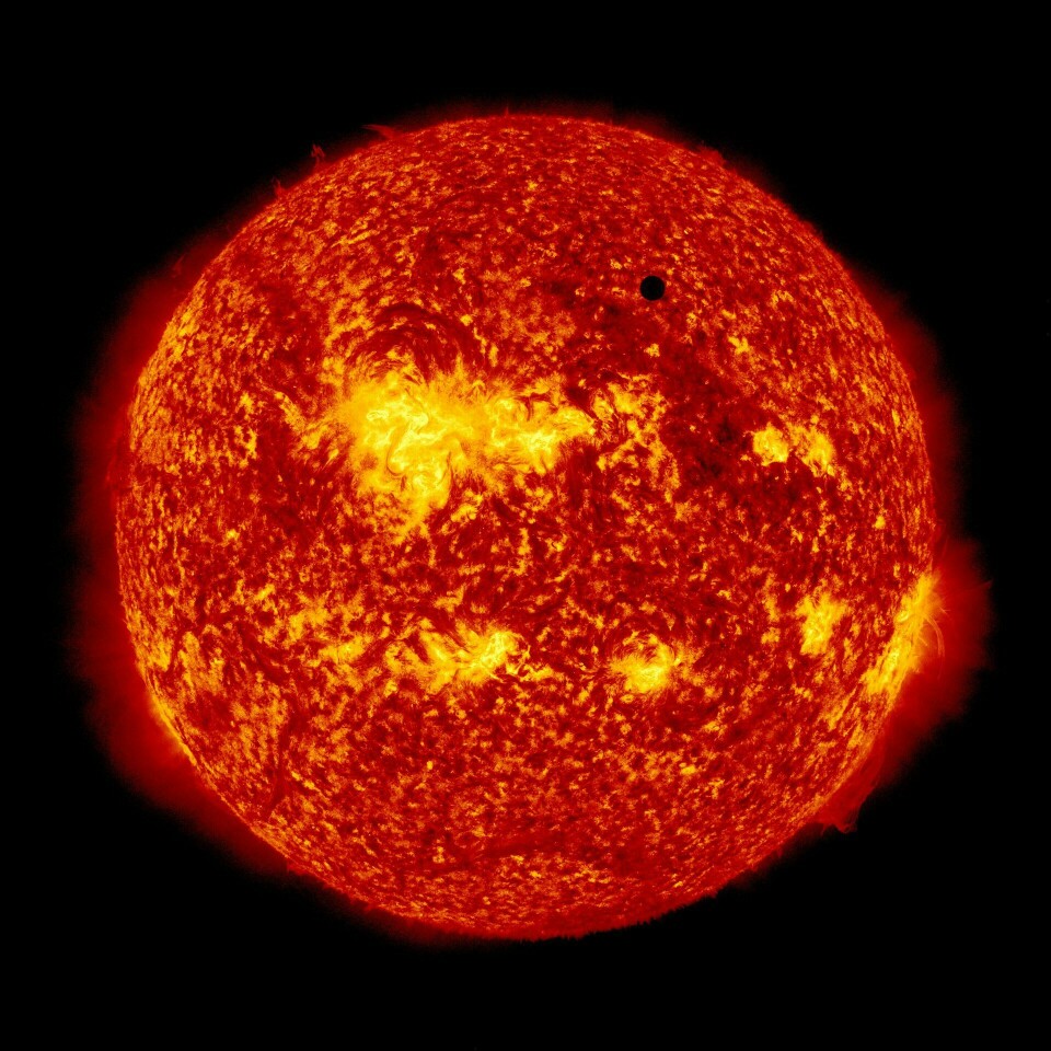 The image shows Venus (black dot at top right) passing in front of the Sun.