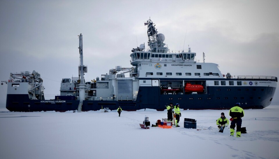 Forskningsskip ved iskanten i arktis med  forskere på isen. Foto