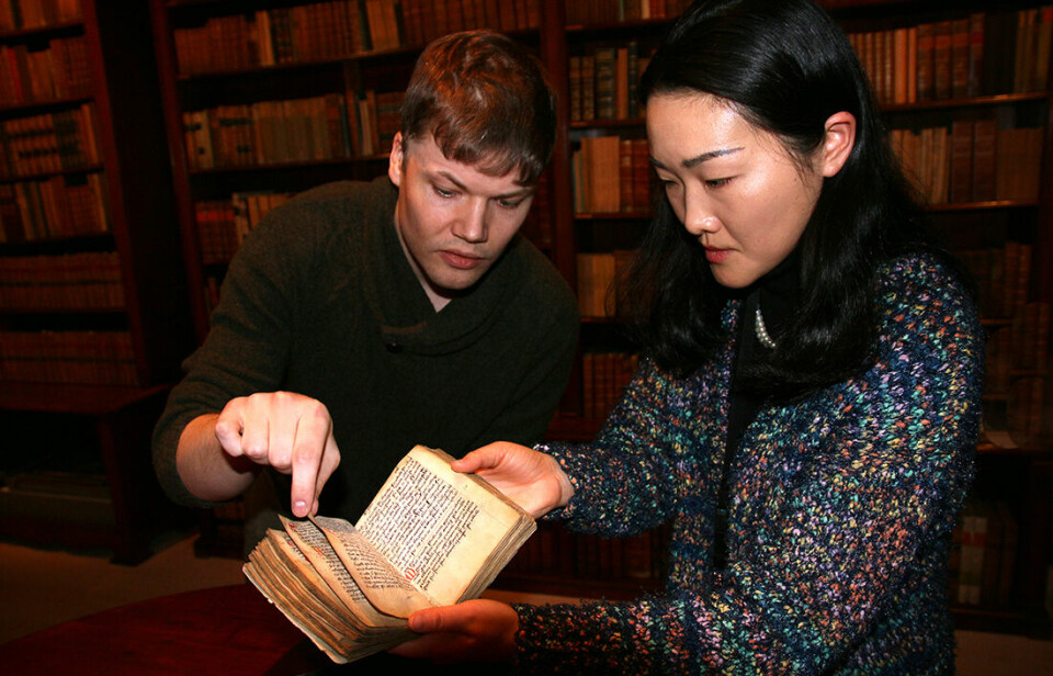 Dette brukseksemplaret av Landsloven er i Gunnerusbibliotekets eie. Universitetsbibliotekarer Per-Olav Broback Rasch og Aming Shi viser den fram.