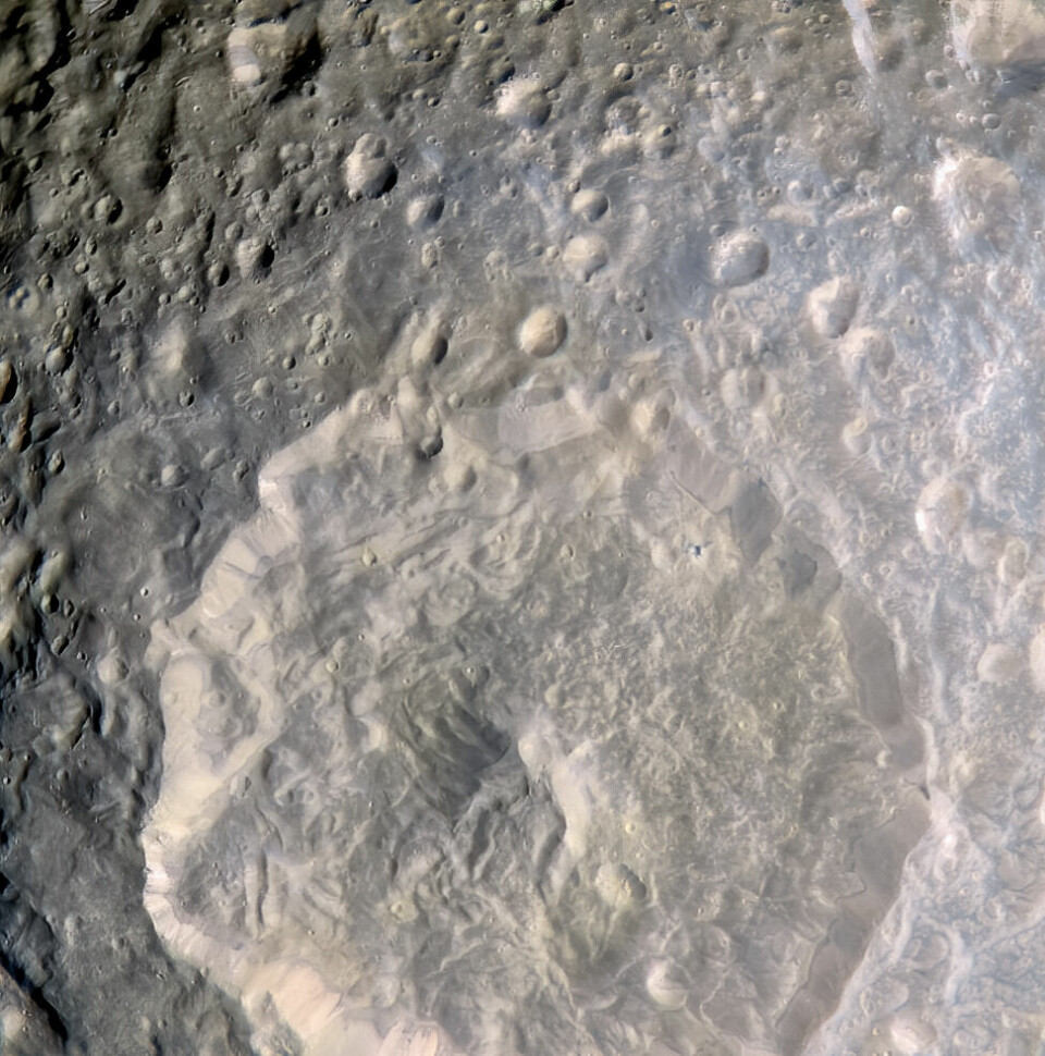 Nærbilde av kjempekrateret og mange andre små kratre på Mimas' overflate.