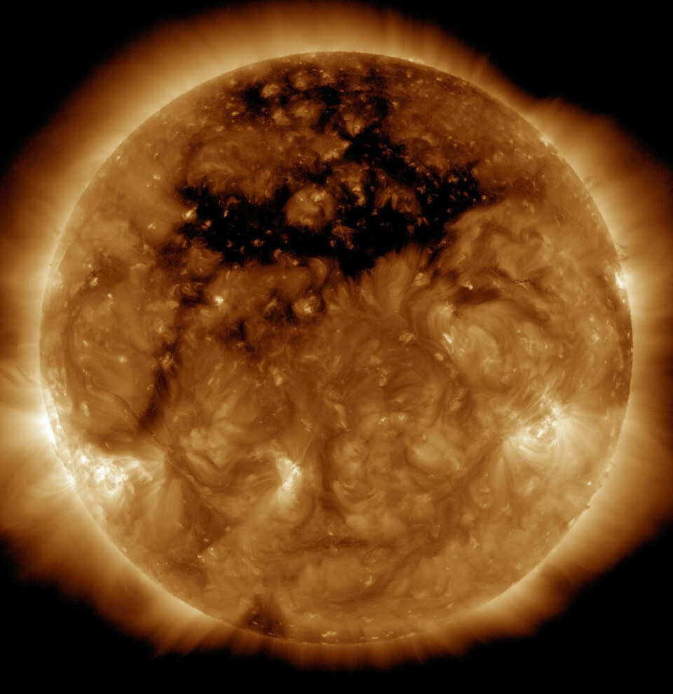 Bilde av sola som viser en mørk flekk som brer seg over en stor del av overflaten som peker mot oss.