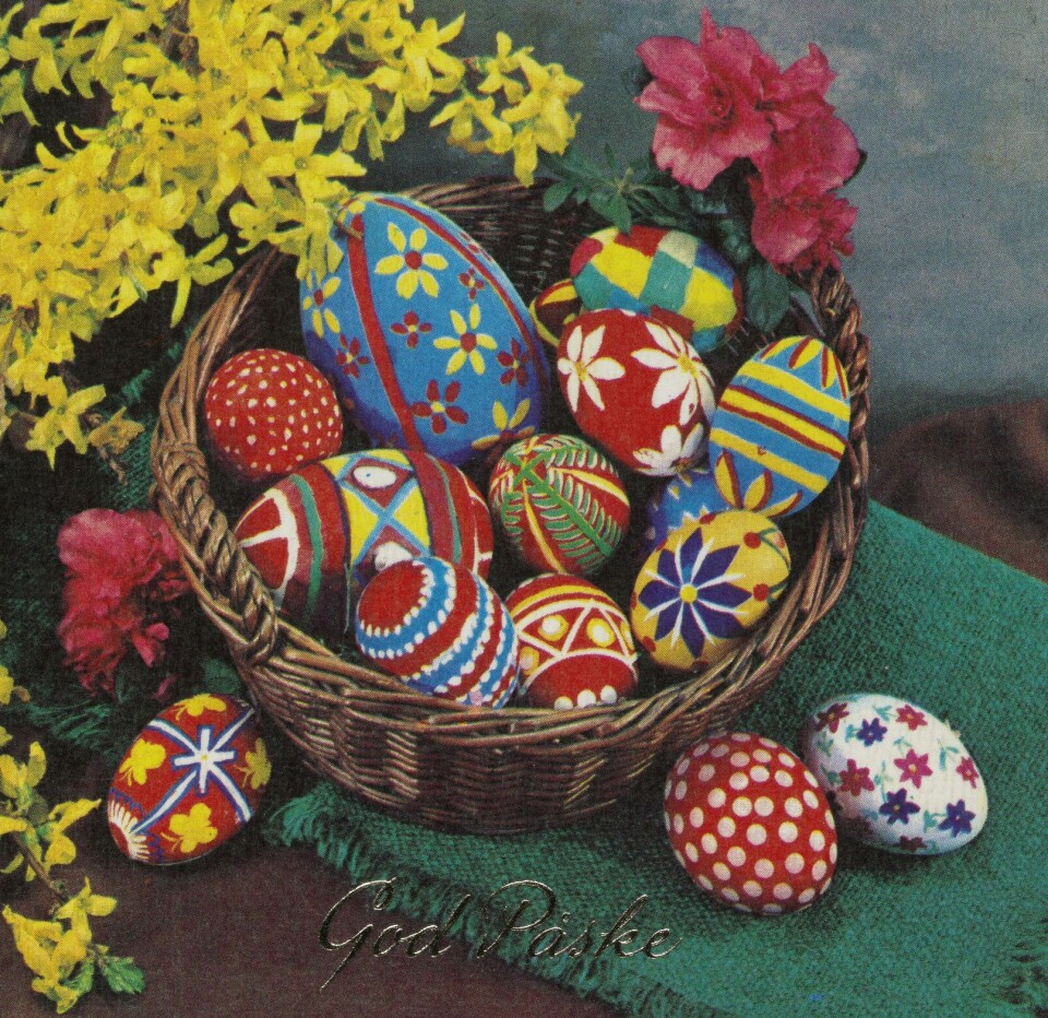 Et påskekort fra 1970 viser dekorerte påskeegg i en kurv. En illustrasjon av en kurv fylt av egg i forskjellige størrelser som er dekorert i forskjellige farger og mønstre.
