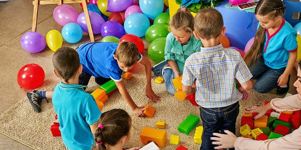 Barn som leker på gulvet med fargerike leker.