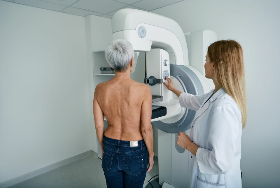 Kvinne og helsearbeider ved mammografimaskin.
