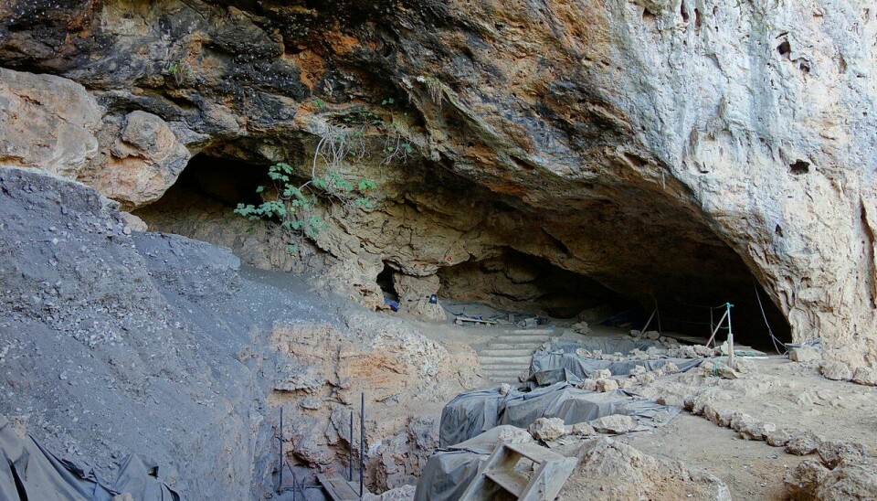 Stiger og trapper leder opp til inngangen til en hule i fjellet.