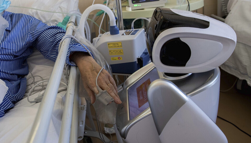 Seks roboter hjalp til ved sykehuset Ospedale di Circolo i Italia under koronapandemien. En robot med skjerm står ved en sykeseng.