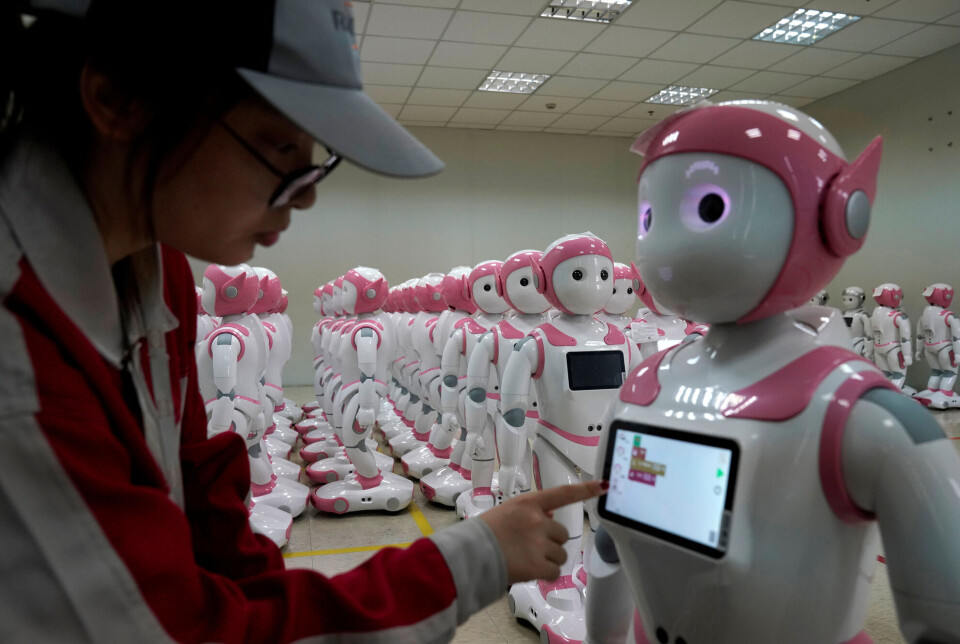 Roboten iPal fra Kina er laget for å holde barn med selskap. Mange roboter i barnestørrelse av samme type står på rekker.