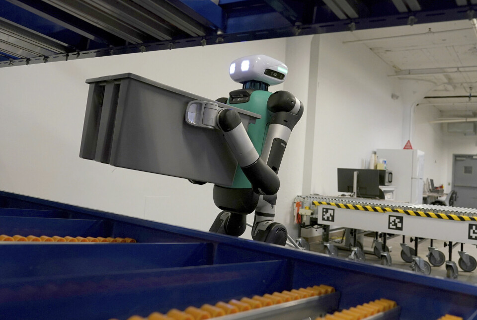 En robot løfter en boks fra et samlebånd.