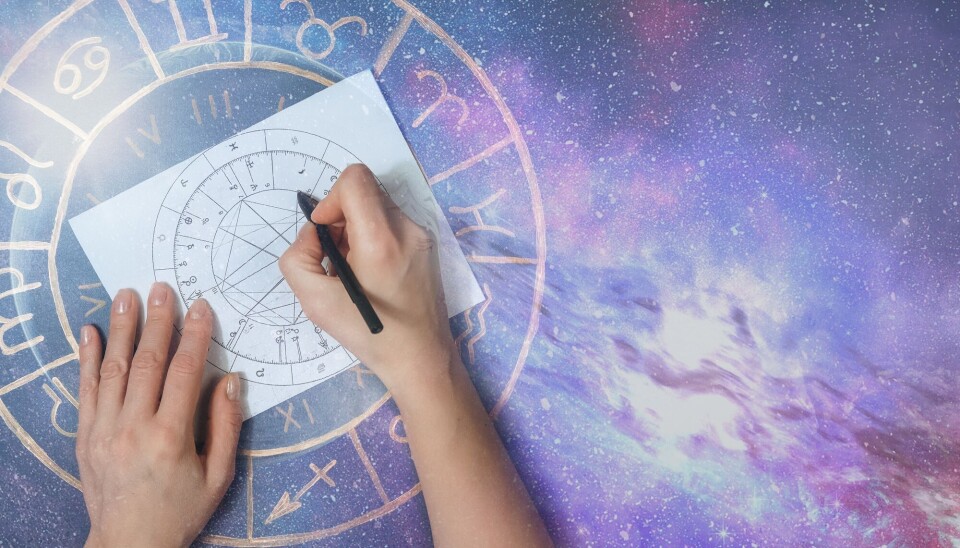 Mange tror på astrologi selv om det ikke er noe innen fysikken eller astronomien som tilsier at fjerne himmellegemer skulle påvirke personligheten vår. Hender tegner opp et astrologisk diagram på et papir, over en bakgrunn med lilla stjerner og galakser.