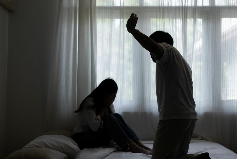 Mann som truer kvinne på en seng med vold
