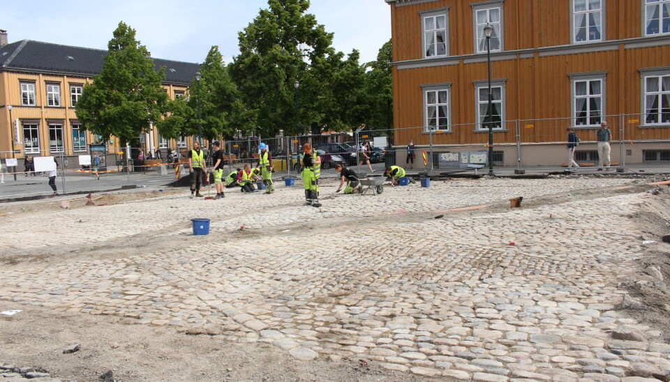Arkeologer fra NIKU renser frem den forseggjorte steinbrolegningen fra ca. 1870 som ble avdekket under moderne asfalt på Torvet i Trondheim i 2016. Utgravningene på Torvet ga en sjelden anledning til å dokumentere etterreformatoriske kulturlag og strukturer i denne delen av byen.