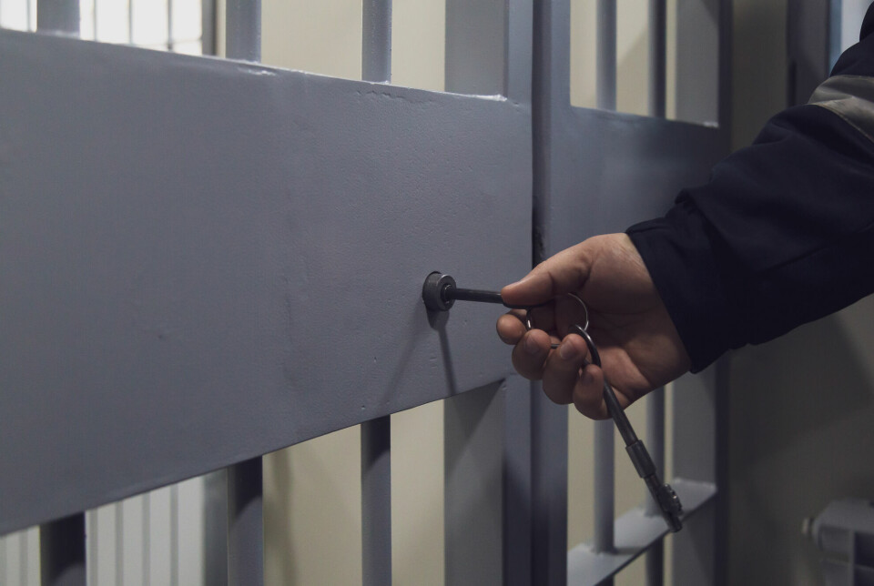 Hånd som låser en fengselscelle