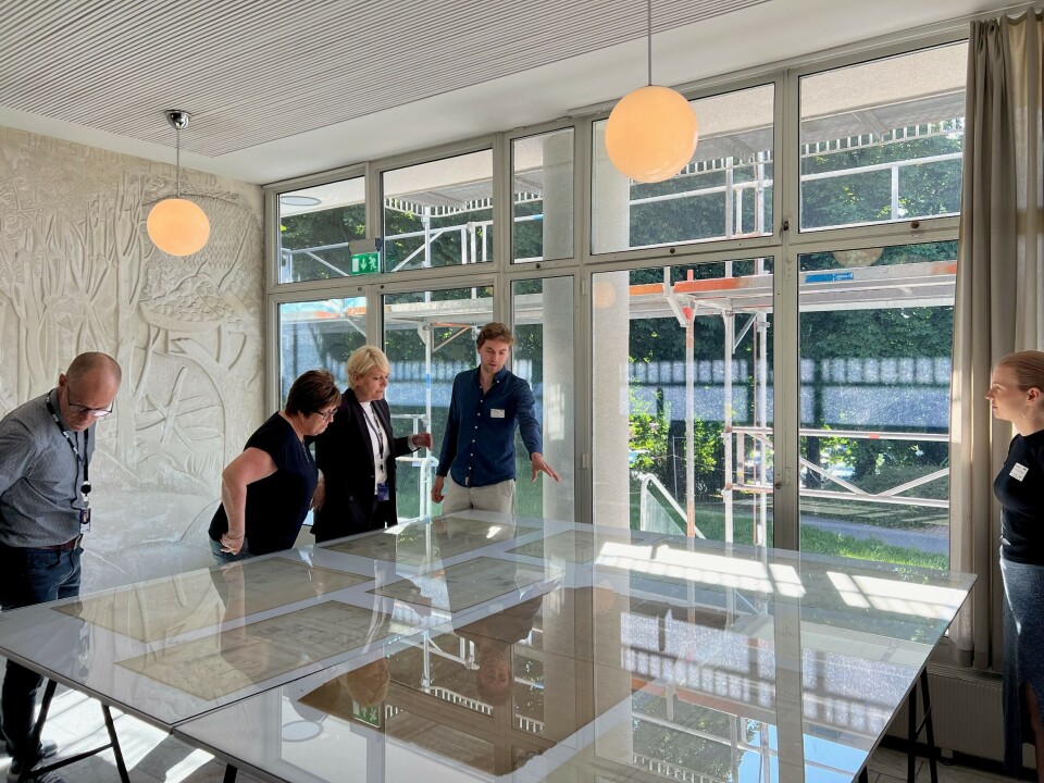 Arkitektstudentene Jonas Nilsson og Ida Nergaard viser kringkastingssjef Vibeke Fürst Haugen originaltegninger av Kringkastingshuset fra perioden 1938–43, stilt ut i Radioresepsjonen på Marienlyst.