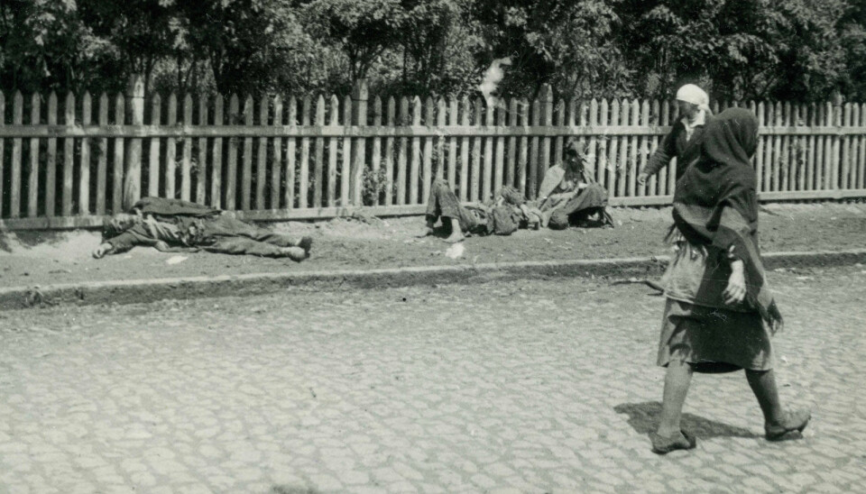Sultende ligger i gatene i Kharkiv i 1933. I løpet av bare noen måneder sultet over tre millioner ukrainere i hjel. Gammelt bilde i sort-hvitt. Mennesker ligger døde eller døende på fortauet, mens forbipasserende går forbi.