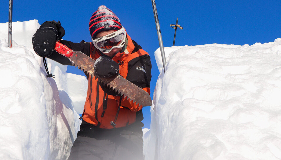 Ta ut blokker loddrett. Mann som sager i snø