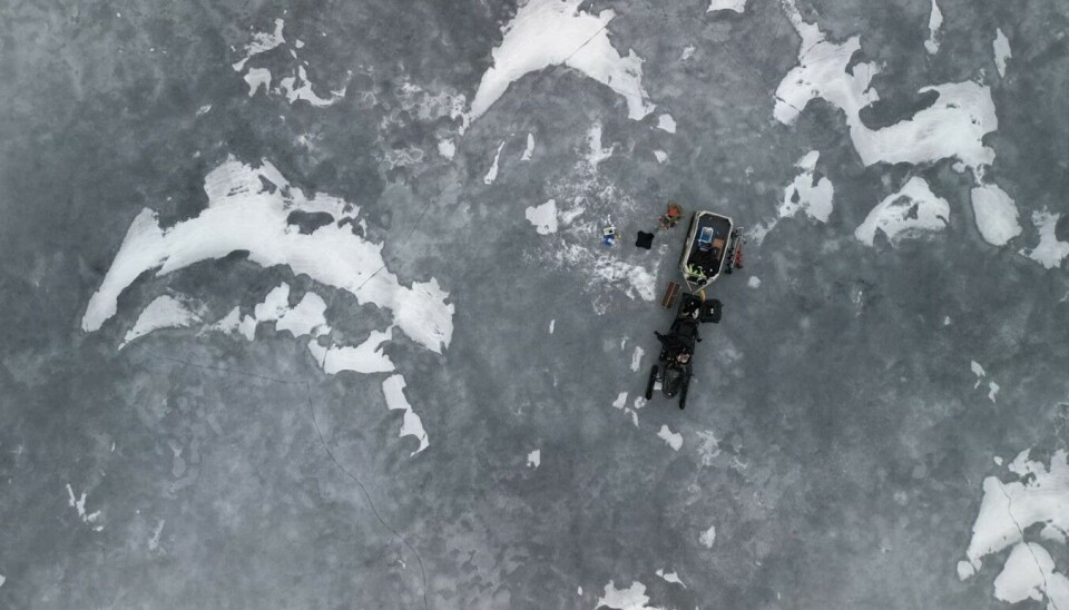 Snøen er snart borte fra isen. Snø som har smeltet og fryst igjen danner lag med mye luftbobler. Stålisen fra begynnelsen av vinteren får økt vanninnhold og blir mørk. Sprekker begynner å bli synlige. Bildet er fra Møsvatn 27. mars 2025. Fugleperspektiv over isen. Foto.