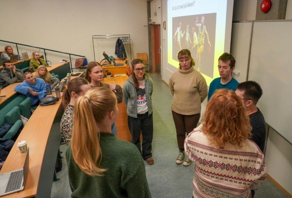 Ut fra ansiktsuttrykkene kan det virke som de fleste som meldte seg, syntes det var litt skummelt å få vite hva de skulle gjøre foran klassen. Unge mennesker står i ring i et auditorium