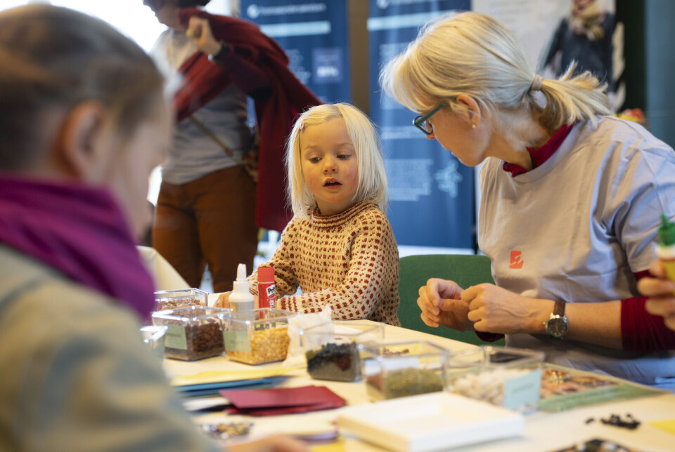 Guri Skeie mener det nye forskningsfunnet passer godt sammen med dagens kostråd. Her fra Forskningsdagene da Skeie var med på et arrangement for familier om de nye kostrådene på Universitetsmuseet i Tromsø. Forsker med barn rundt et bord.