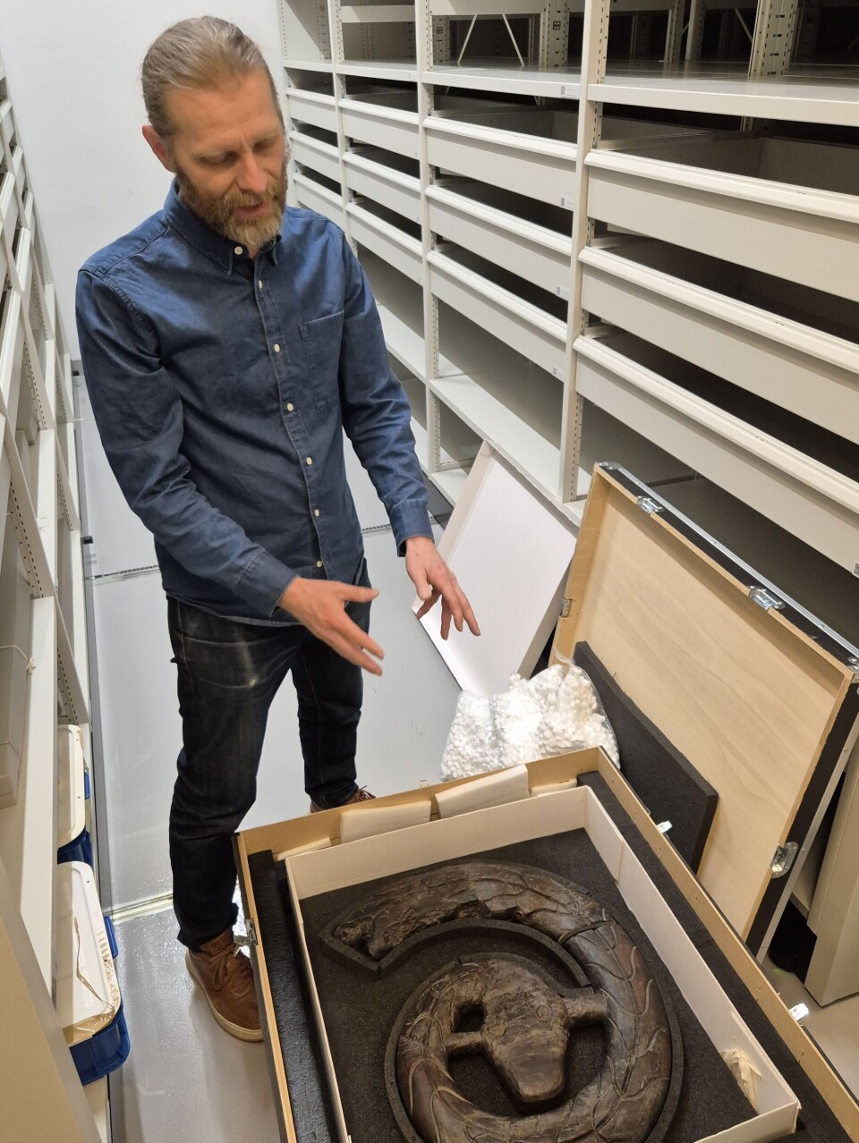 Vegard Vike viser fram rekonstruksjonen av de originale bitene. På dette tidspunktet var Ormen på Kulturhistorisk museums magasin på Økern i Oslo.