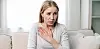 Kvinne i sofa som ser engstelig ut.