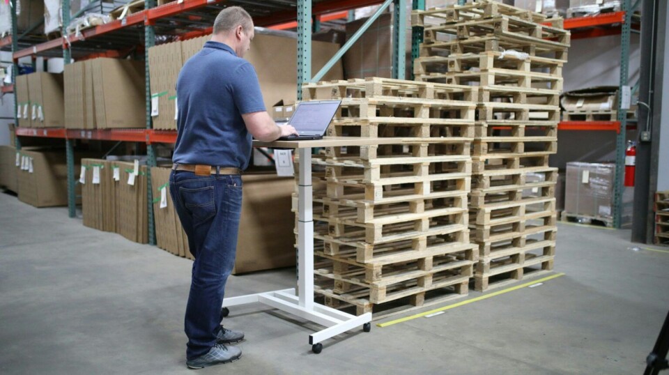 Mange arbeidstakere er plaget av hodepine på jobb. Mann med paller