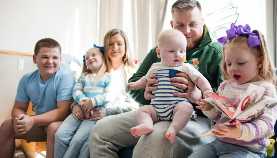 Gutten sammen med familien sin etter behandlingen. Mor og far sitter med fire barn.
