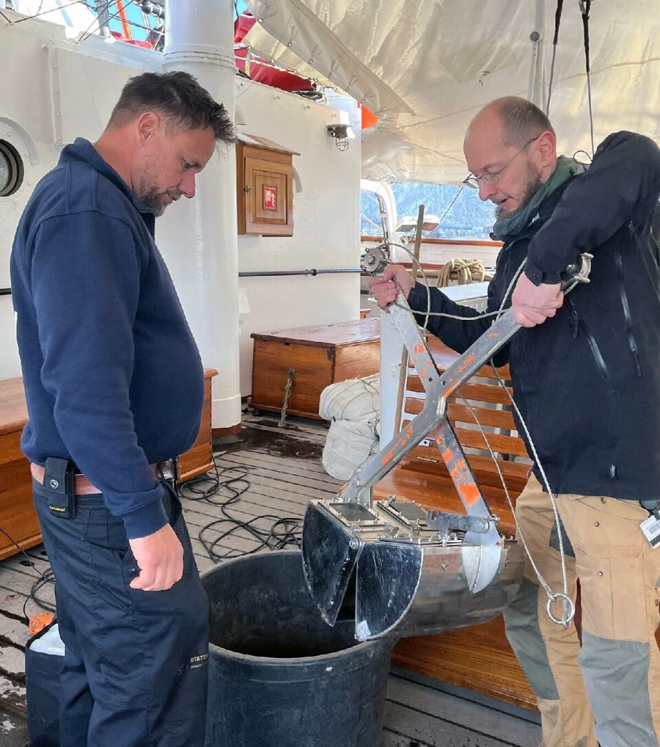 Andreas Altenburger (til høyre) demonstrerer hvordan grabben virker for båtsmann Jesper Rosenmai om bord på «Statsraad Lehmkuhl». To menn på båt