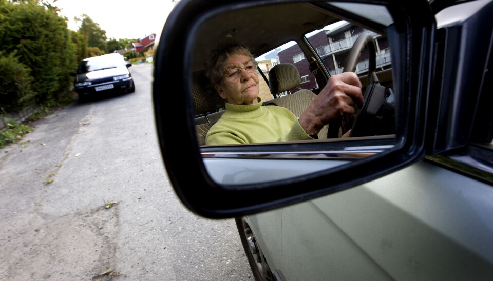 Å miste førerkortet kan være vanskelig, og det kan være risikabelt for eldre å bruke alternative transportmidler. Eldre dame i bil fotografert gjennom sidespeilet på bilen.