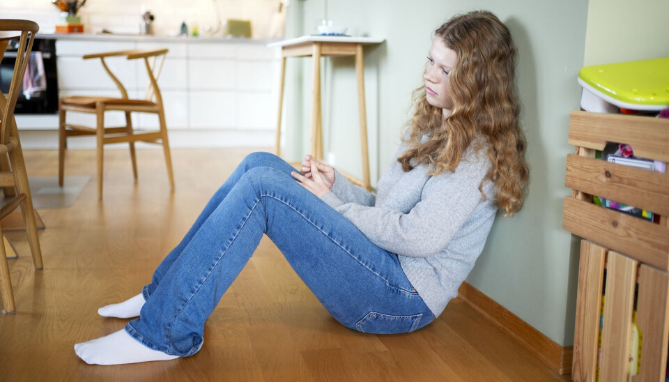 ADHD og autisme har ofte blitt sett på som «guttediagnoser», noe som har ført til underoppdagelse blant jenter. Jente sitter på gulvet og tenker.