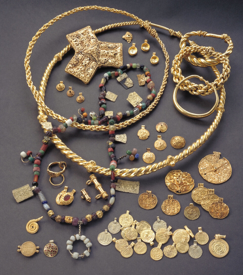 Hoenskatten består av 50 smykker, mest gull, men også noe sølv. Også 20 mynter og 170 perler lå gravd ned i myra. Perlekjedet på bildet er satt sammen av museet. Gullsmykker, sølv, perler og mynter.