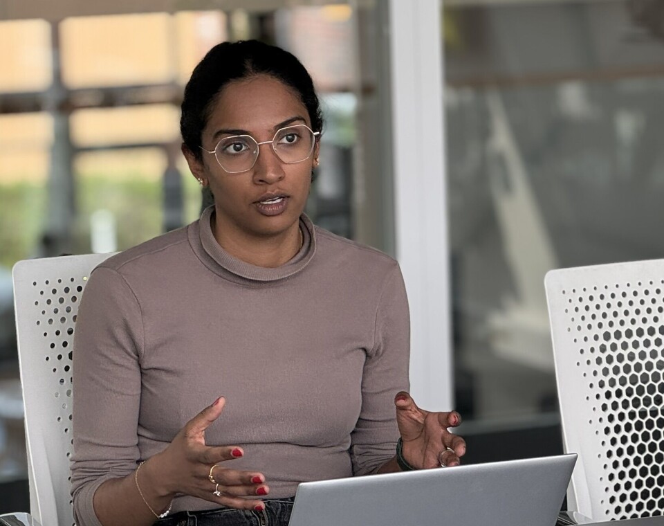 Vahiny Gnanasekaran tar doktorgrad om menneskelige faktorer i cybersikkerhet ved SINTEF og NTNU. En kvinne forklarer noe bak en laptop.