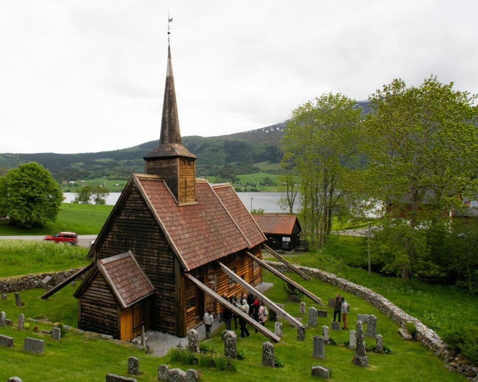 Rødven stavkirke er dekket med kledningsbord. Bak disse skjuler portalen seg til vanlig. Nylig ble kirken undersøkt og portalen avkledd. Rødven stavkirke med kirkegården rundt.