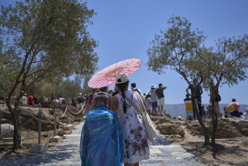 Turister under en hetebølge i Aten i slutten av juni, der temperaturene nærmet seg 40 grader celsius.