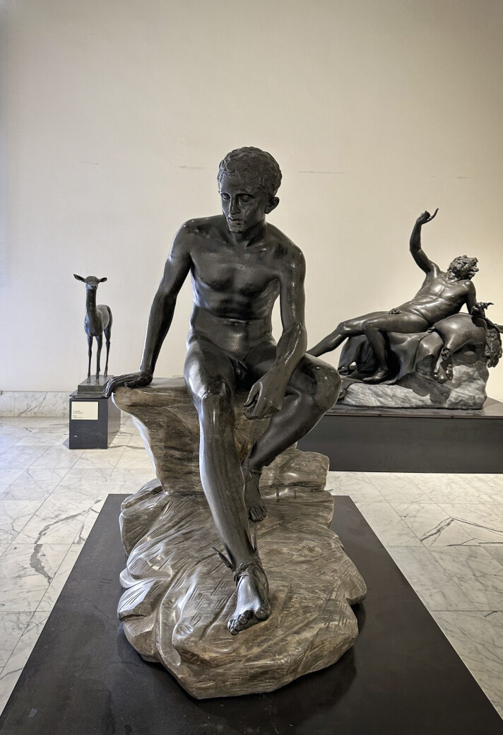 Statuer som er gravd ut i Pompeii og Herculaneum. Statue i bronse av en sittende mann.