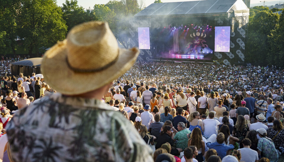 Det var trangt om plassen da den svenske duoen First Aid Kit spilte på Øyafestivalen i Oslo i 2022. Men ikke alle har glede av musikk. Mann i lys stråhatt og hvit og grønn hawaiiskjorte står med ryggen til, nærmest kameraet. Et folkehav foran ham, med scenen i bakgrunnen.