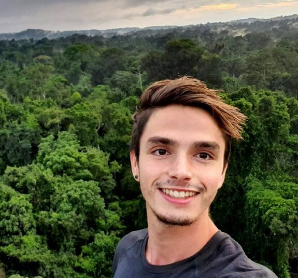 Thomas Luypaert forsker på lyder fra regnskogen Amzonas. Slik kan han finne ut hvilke dyr som bor der. Selfie av en smilende, ung mann med regnskog i bakgrunnen.