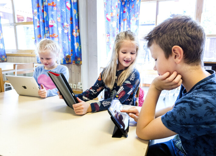 94 prosent av alle elever i norsk skole har fått utdelt et lesebrett eller en PC. Tre barn i klasserom, alle med nettbrett.