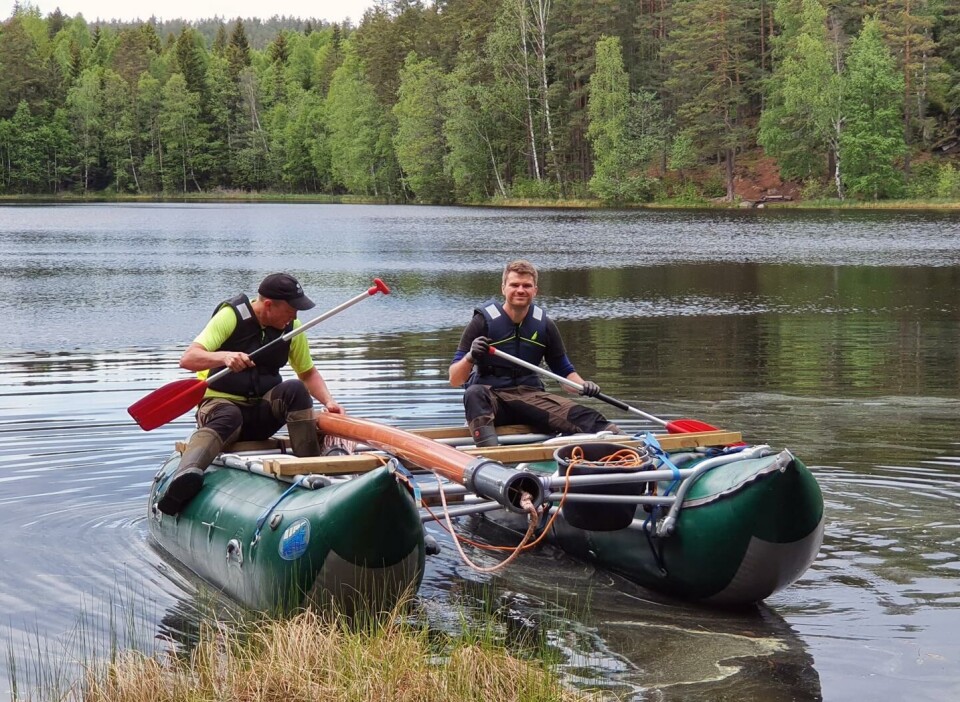 Anders Romundset (t.v.) og Isak Roalkvam legger til land med en kjerneprøve fra Askevannet i Oslo. Kjernene viser utviklingen til landhevingen.