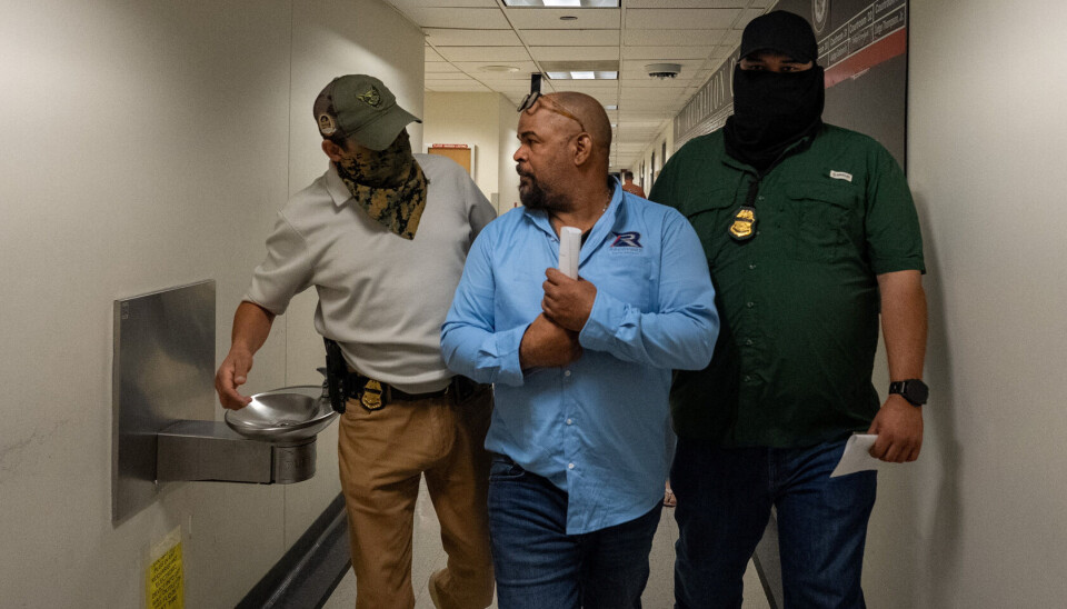 En innvandrer blir arrestert i domstolen for innvandringssaker i New York 18. september. Mann sammen med to maskerte agenter.