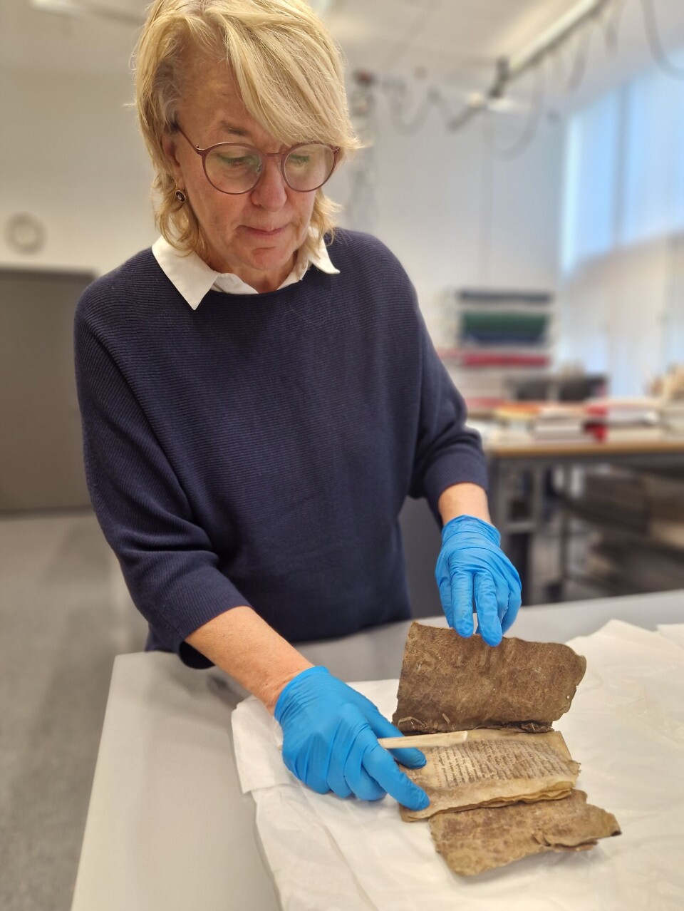 Boka blir oppbevart i høy luftfuktighet i magasinet. Men konservator Chiara Palandri tok den forsiktig fram da forskning.no var på besøk. Chiara Palandri tar fram den gamle boka.