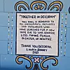 Malt plakat med teksten: Together i Decorah. This mural is dedicated to all immigrants, refugees and populations who have searched for a new home due to war, genocide, loss, famine, plague, disaster, or injustice.
