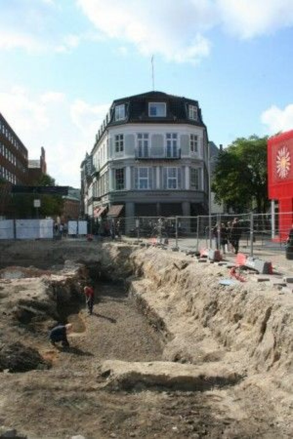 Bildet viser det opprinnelige gatebelegget, som ligger samme sted som dagens Overgade. Litt bak arkeologen som kneler, ble det første kattefunnet gjort. (Foto: Odense Bys Museer)
