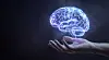 En lysende, digital hjerne svever over en utstrakt hånd mot mørk bakgrunn.