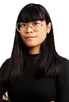 Portrett av ung person med briller og sort genser mot hvit bakgrunn.