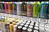 Rader med energidrikker i butikkhylle, med forskjellige bokser.