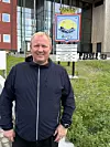 Tor-Erik Labahå står foran Vardø kommunes skilt utenfor rådhuset.