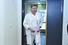 Are Holm står iført hvite legeklær i en døråpning.