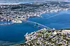 Utsikt over Tromsø med bro, havn og tettbebyggelse langs kysten.