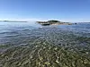 Kortsiden av en svært liten øy sett fra havet.