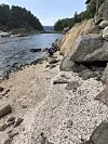 En steinete liten strand med masse knuste steinkoraller på.